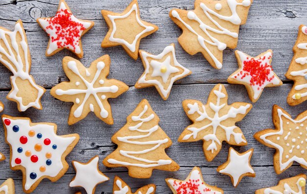 Biscoitos caseiros de abeto estrela de Natal e flocos de neve com glacê branco