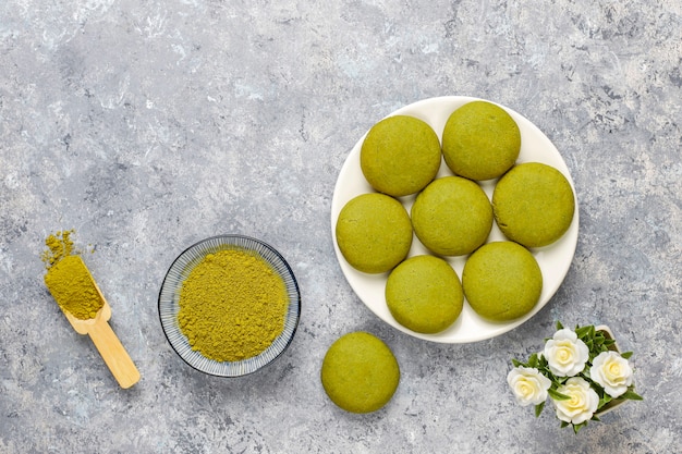 Biscoitos caseiros de chá verde matcha com pó de matcha em concreto cinza