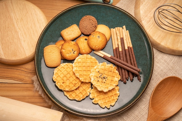 Biscoitos caseiros de manteiga e biscoitos de chocolate e biscoitos palitos no fundo de madeira