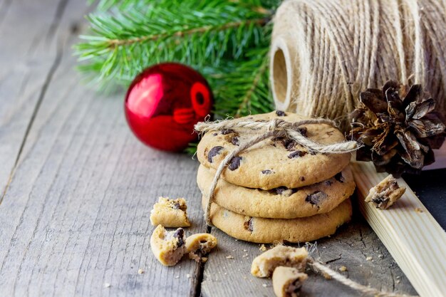 Foto biscoitos caseiros e uma chávena de chá com mel e galhos de thuja em uma mesa de madeira