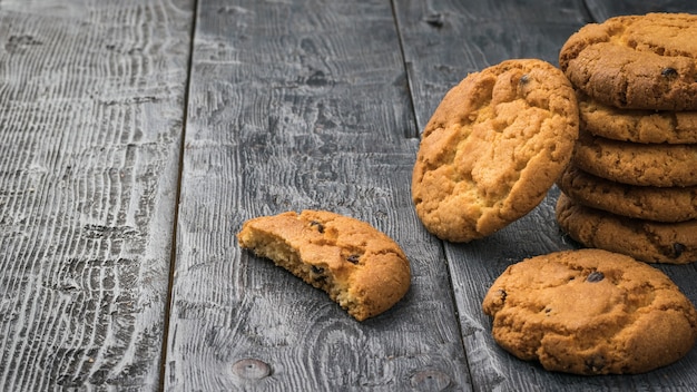 Biscoitos caseiros frescos com gotas de chocolate em uma mesa de madeira