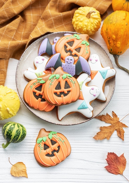 Biscoitos caseiros multicoloridos de Halloween em fundo branco de madeira