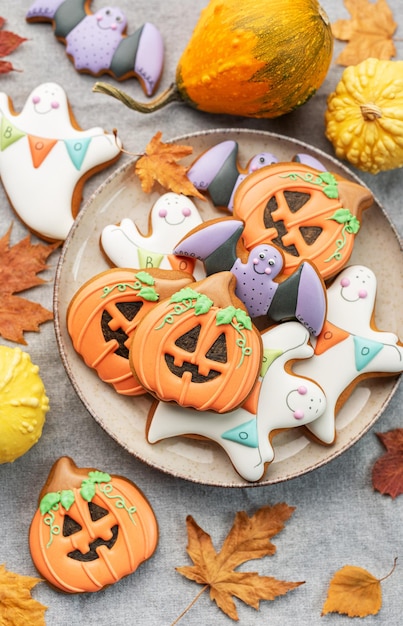 Biscoitos caseiros multicoloridos de Halloween em fundo branco de madeira