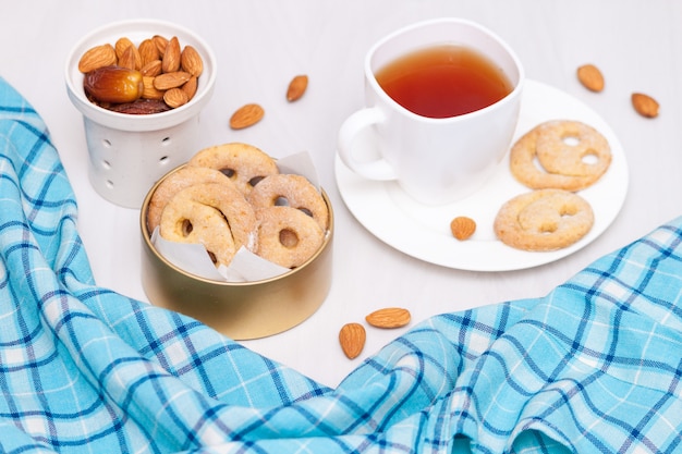 Biscoitos caseiros sorriso com uma xícara de chá preto. bom dia ou tenha um bom dia. postura plana.