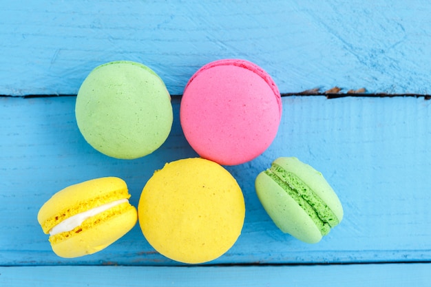 Biscoitos coloridos macaron na mesa de madeira azul vintage