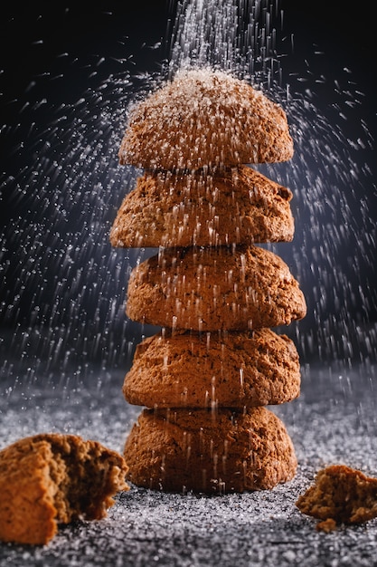 Biscoitos com açúcar em pó na placa de pedra escura