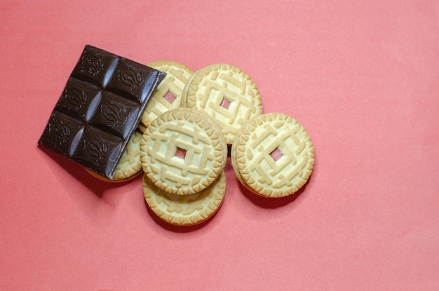 Biscoitos com chocolate escuro em um fundo rosa