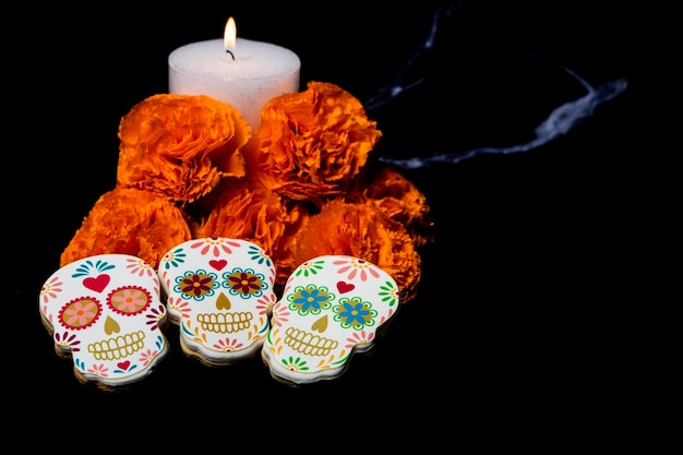 Foto biscoitos com formas de catrinas e flores com velas para celebrar o halloween ou o dia dos mortos