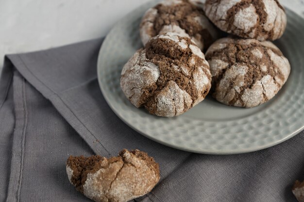 Biscoitos com rachaduras de chocolate. Biscoitos saborosos caseiros em uma tigela cinza sobre uma mesa.