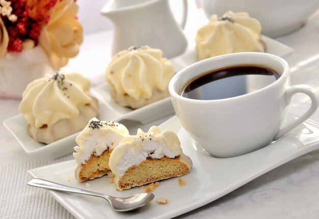 Biscoitos com recheio de zefirnoy em esmalte de leite com uma xícara de café