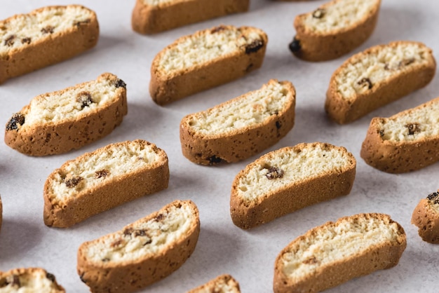 Biscoitos crocantes com passas e amêndoas no padrão de fundo cinza horizontal acima