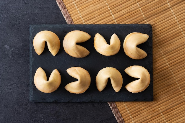 Biscoitos da sorte tradicionais fundo de ardósia preta xA