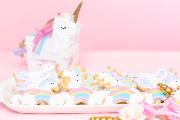 Biscoitos de açúcar de unicórnio decorados com glacê real na festa de aniversário das crianças.