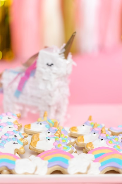 Foto biscoitos de açúcar de unicórnio decorados com glacê real na festa de aniversário das crianças.
