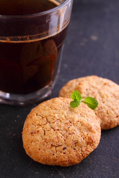 Biscoitos de amêndoa em um fundo preto com uma xícara de café