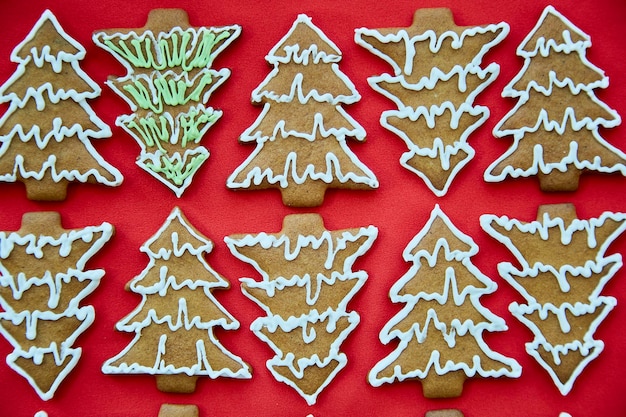 Biscoitos de árvore de natal de gengibre caseiro de natal fecham um fundo de cozimento artesanal diferente cartão festivo com atmosfera estética de natal feliz natal e conceito de aconchego em casa