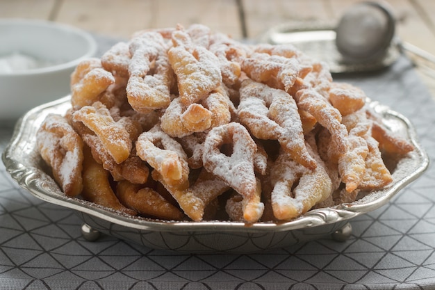 Biscoitos de asas de anjo, um prato doce europeu tradicional para o carnaval. Estilo rústico.