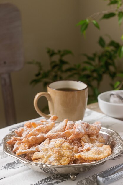 Biscoitos de asas de anjo, um prato doce europeu tradicional para o carnaval. Estilo rústico.