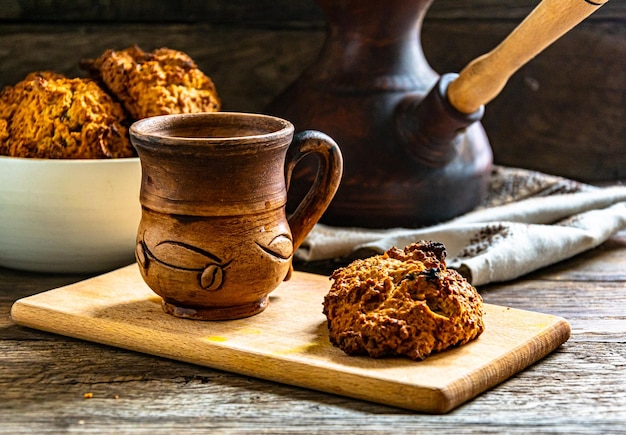 Biscoitos de aveia caseiros e café preparado em um prato de cerâmica na mesa da cozinha.
