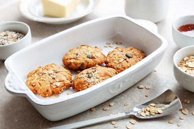 Biscoitos de aveia caseiros tradicionais com sementes de gergelim e girassol e ingredientes para assá-los