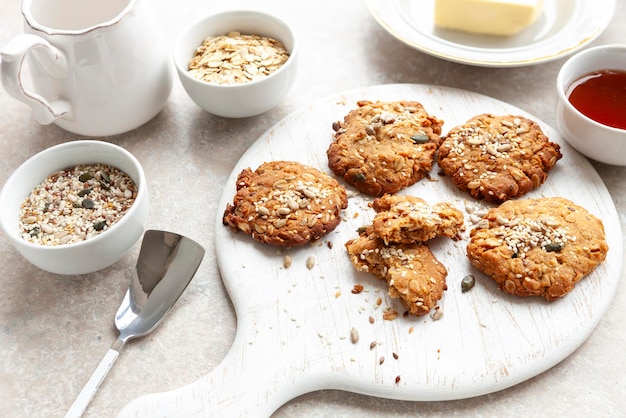 Biscoitos de aveia caseiros tradicionais com sementes de gergelim e girassol e ingredientes para assá-los