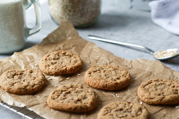 Biscoitos de aveia cozidos frescos na assadeira, leite e aveia no fundo