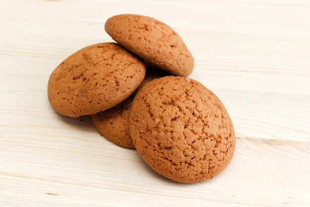 Biscoitos de aveia em uma mesa de madeira branca.