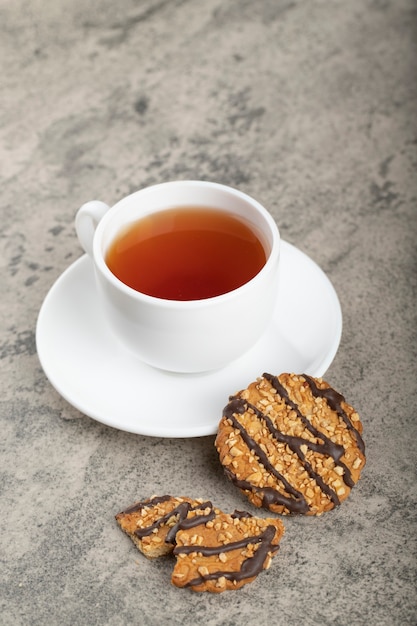 Biscoitos de aveia frescos com cobertura e chá na pedra.