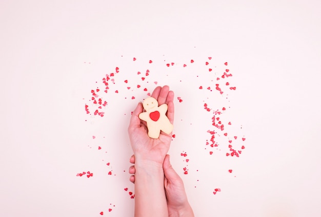 Biscoitos de biscoito amanteigado na forma de um homem com um coração, uma pequena decoração de corações, doces.