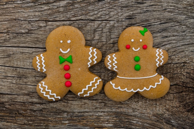 Foto biscoitos de casal de pão de mel de natal na mesa de madeira rústica. vista do topo