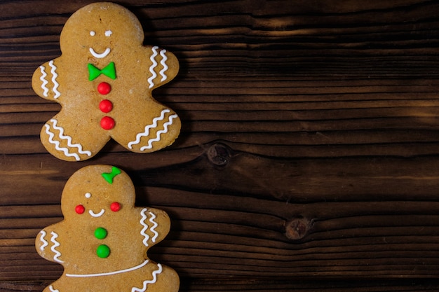 Biscoitos de casal de pão de mel de natal na mesa de madeira. vista do topo