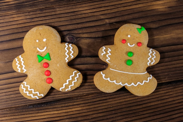 Biscoitos de casal de pão de mel de natal na mesa de madeira. vista do topo