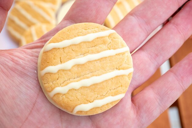 Foto biscoitos de chocolate branco com limão e laranja em um prato rosa em uma mesa de café