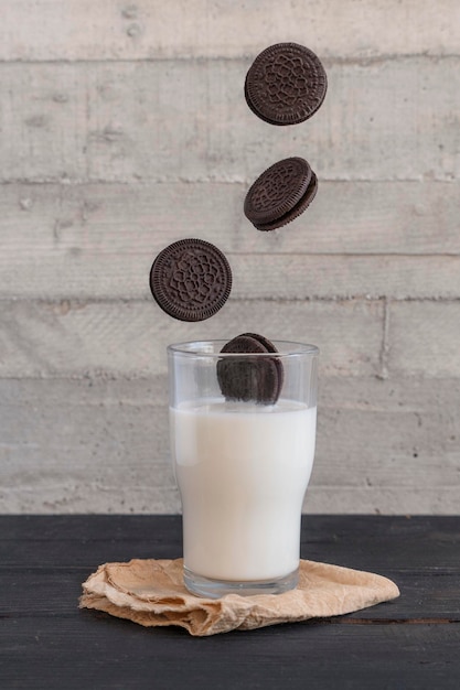 Biscoitos de chocolate caindo empilhados em um copo de leite