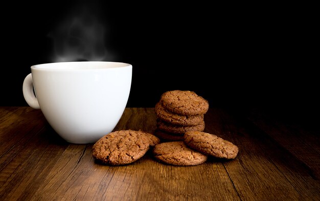 Biscoitos de Chocolate caseiros comer com café quente em fundo de madeira
