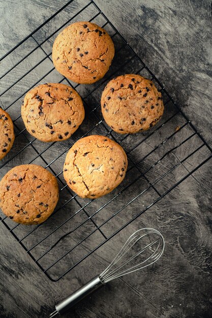 Biscoitos de chocolate caseiros na bandeja de resfriamento de cozimento preto e fundo abstrato