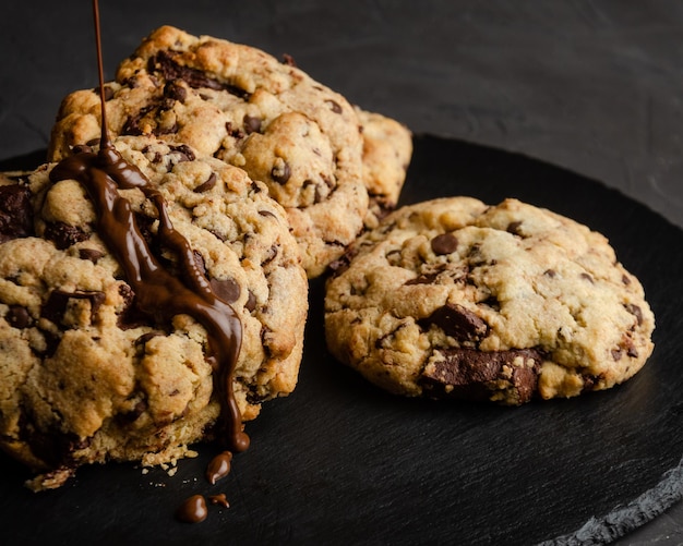 Biscoitos de chocolate com calda de chocolate, em fundo preto