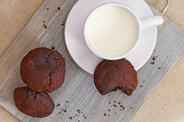 Biscoitos de chocolate com leite na mesa de madeira.