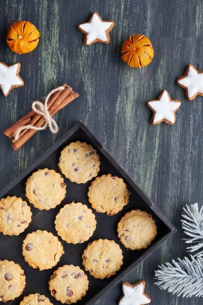 Biscoitos de chocolate de Natal, plana leigos com especiarias e decorações de inverno no escuro.