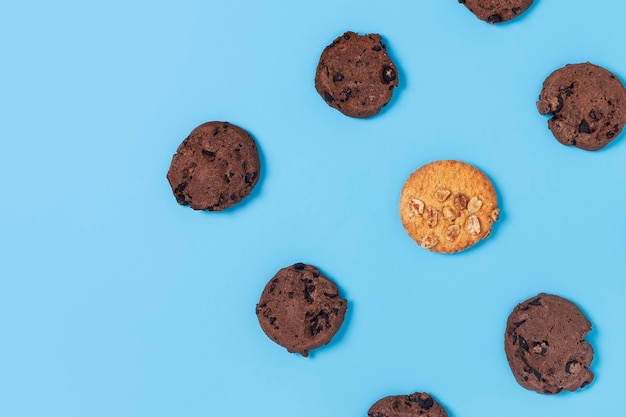 Biscoitos de chocolate e brancos em um fundo azul Vista superior plana lay