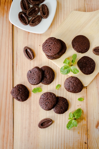 Foto biscoitos de chocolate e folha de hortelã na placa de madeira