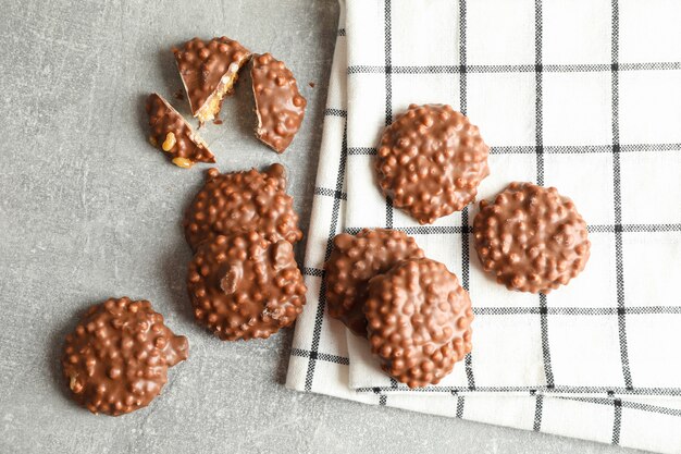 Biscoitos de chocolate e toalha de cozinha na mesa cinza, vista superior