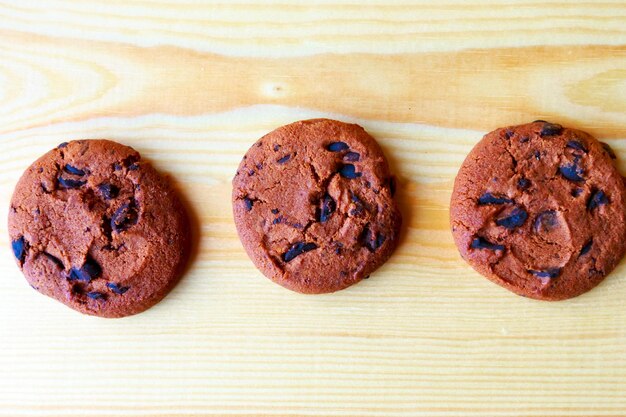 biscoitos de chocolate e xícara de café em fundo de madeira