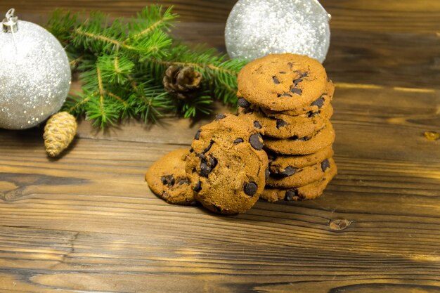 Biscoitos de chocolate na frente da decoração de natal na mesa de madeira