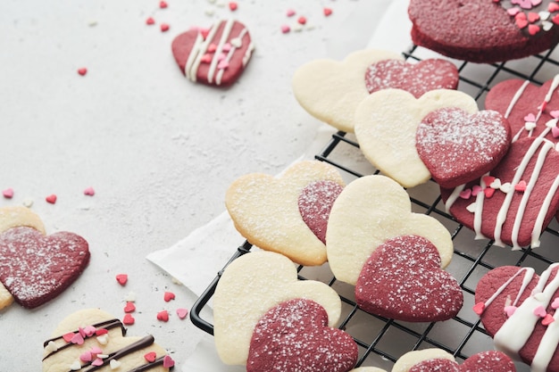 Biscoitos de dia dos namorados Biscoitos amanteigados dentro de doce coração vermelho com cobertura de chocolate no prato rosa em fundo cinza Dia das mães Dia da mulher Feriados doces assando Cartão de dia dos namorados Vista superior