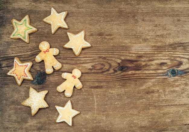 Biscoitos de gengibre caseiro de Natal de homem e estrelas sobre fundo de madeira rústico, vista superior