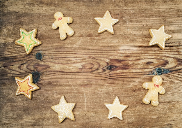 Biscoitos de gengibre caseiro de Natal do homem e as estrelas sobre a vista rústica de madeira, superior