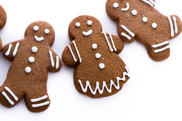 Biscoitos de gengibre caseiros decorados com glacê branco sobre fundo branco.