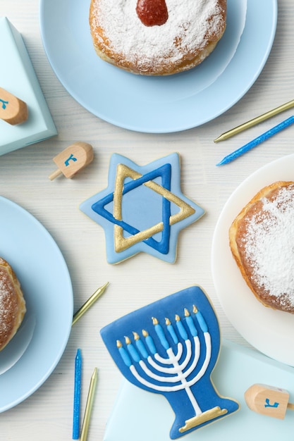 Biscoitos de gengibre com símbolos judaicos e donuts na vista superior de fundo branco