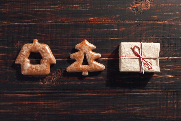 Biscoitos de gengibre de Natal em forma de uma árvore de Natal e presentes de artesanato em um de madeira.